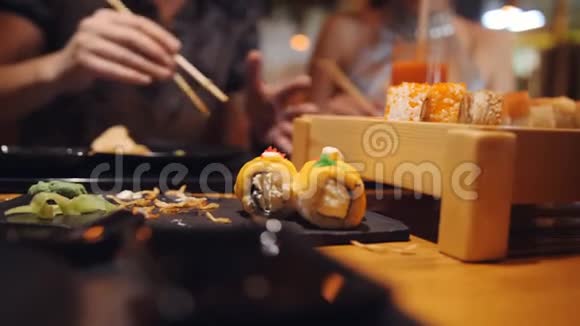 女儿和爸爸的特写在一家亚洲餐馆用木棍拿木筷寿司视频的预览图