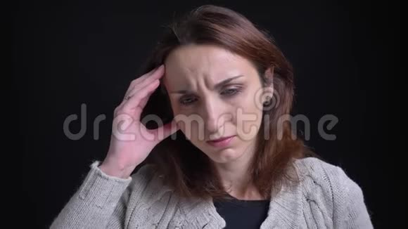 白人中年妇女在黑色背景下头痛的肖像视频的预览图