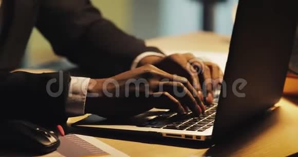 疲惫的年轻黑人商人在笔记本电脑上打字他在夜间办公室工作斯坦迪卡姆视频的预览图