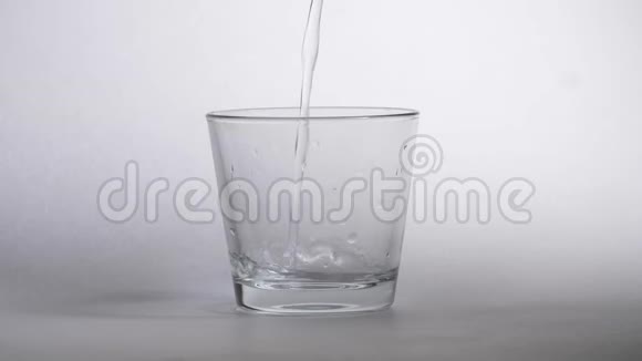 将新鲜纯净水倒入桌上的透明玻璃杯中健康和饮食理念视频的预览图