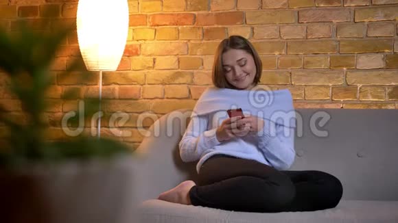 年轻活泼的白种人女性在家中轻松愉快地发短信微笑的特写镜头视频的预览图