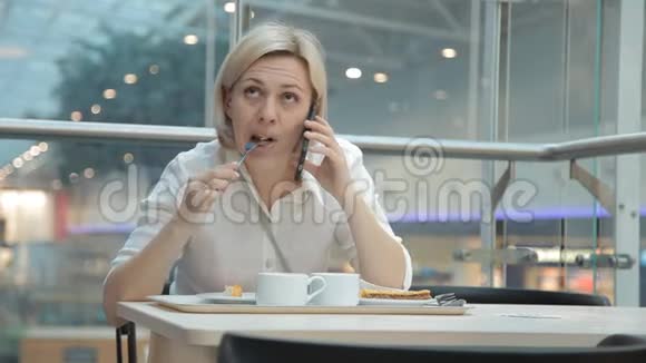 在餐馆吃饭时打电话的女人视频的预览图