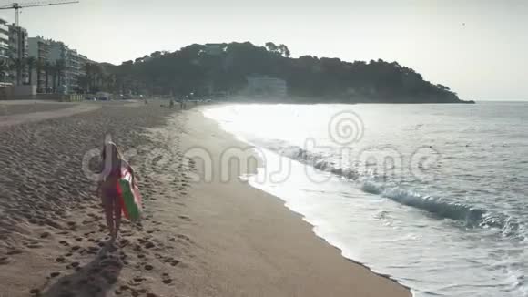穿比基尼的金发女人在沙滩海岸散步视频的预览图
