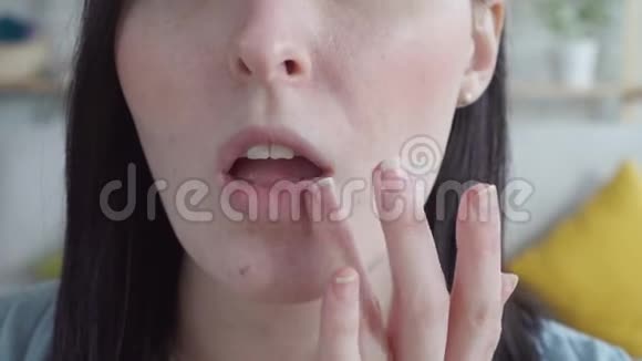 靠近一个年轻的女人抹上皲裂的唇膏视频的预览图