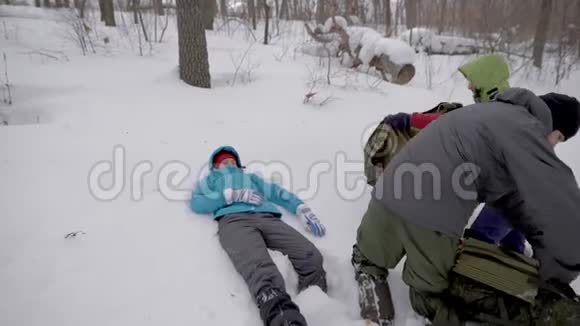 徒步旅行者在冬日的森林里打开担架受伤的女人躺在雪地上急救视频的预览图