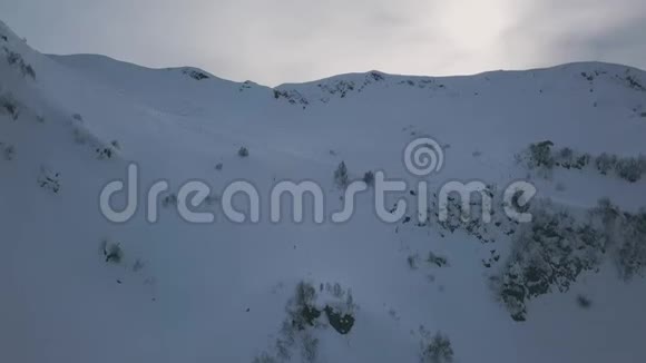 空中飞弹飞过美丽的自然冬季山谷高山被白雪覆盖视频的预览图
