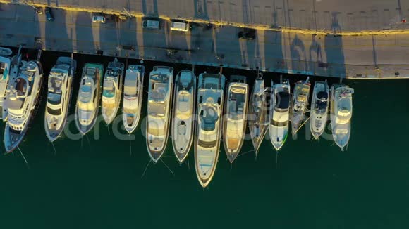 乘坐游艇俱乐部和码头的无人机进行空中观景游艇俱乐部的俯视图海水中的白船码头码头游艇和视频的预览图