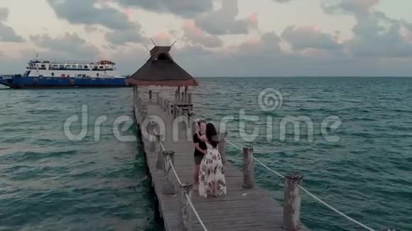 一对恋爱中的情侣在墨西哥坎昆附近的海滨度假胜地日落时接吻视频的预览图