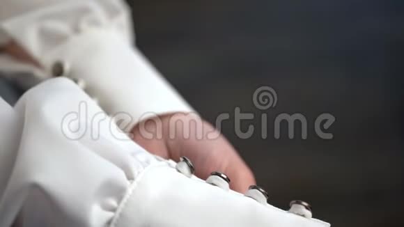 新娘用手触摸婚纱的纽扣视频的预览图