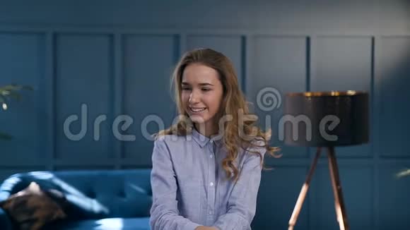 一幅可爱的白种人女人在房间背景上对着镜头的肖像视频的预览图