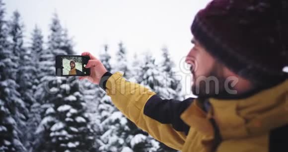 一位年轻有魅力的游客在山上自拍时发现了令人惊叹的雪山森林并非常高兴地拍照视频的预览图
