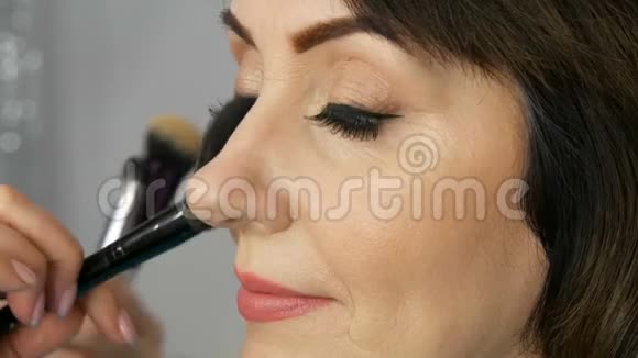 专业化妆师用蓝色的大眼睛为中年女性化妆并绘制箭头视频的预览图