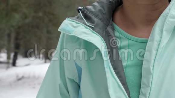白种人年长的女人在下雪的冬季公园跑步之前先把夹克脱掉近距离射击视频的预览图