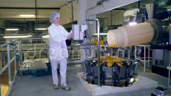 一名妇女检查工厂输送机移动薯片的工作视频的预览图