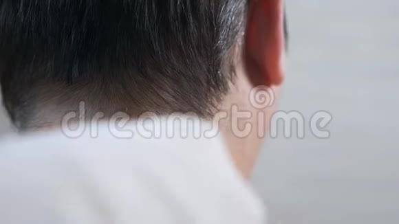 理发师用电动剃须刀修剪棕色头发视频的预览图
