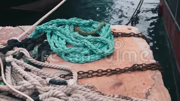 蓝色明亮的渔具躺在码头上关闭系泊绳码头的捕鱼设备近距离观看鱼袋船上视频的预览图