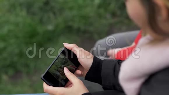 女孩在手机上看照片视频的预览图