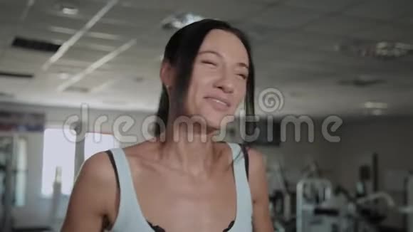 美丽的运动快乐的女人在健身房的跑步机上训练视频的预览图