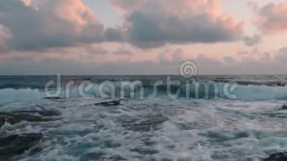 卷起汹涌的巨浪巨大的海浪拍打在岩石海岸波浪飞溅创造泡沫关闭视频的预览图