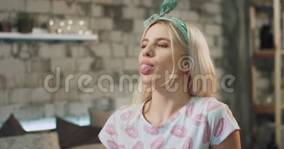 一位金发女郎的肖像在镜头前吃着一颗口香糖并制造了一个大泡泡视频的预览图