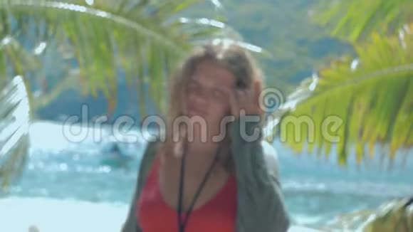 热带海滩上美丽的欧洲年轻女子的慢动作特写镜头镜头对准镜头视频的预览图
