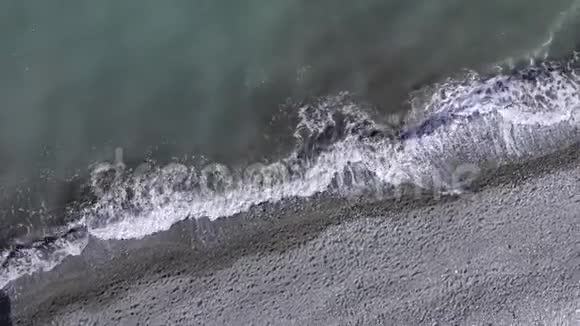 无人驾驶的视野呼唤移动躺在鹅卵石海滩上海浪拍打着海岸视频的预览图