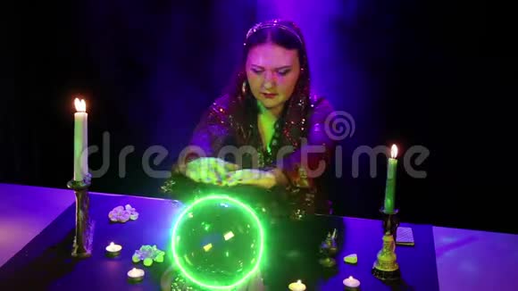 桌上的吉普赛算命先生正在用一个发光绿色的水晶球表演魔术视频的预览图