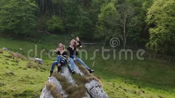 两个女孩坐在北爱尔兰默洛湾的岩石上视频的预览图