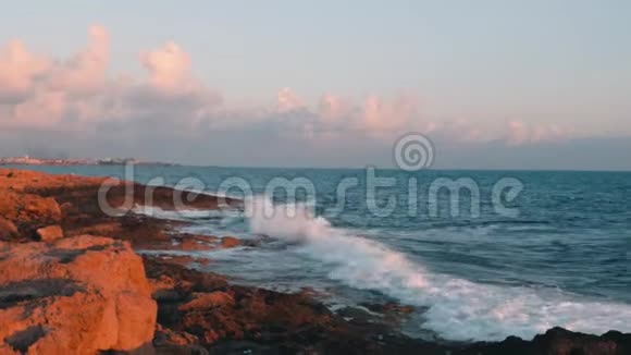 巨大的海浪拍打在岩石海滩上大海波涛飞溅创造泡沫日落时的暴风雨地中海马西视频的预览图