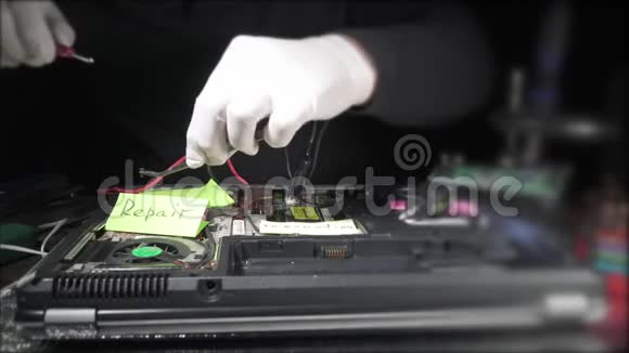戴白手套的人用螺丝刀修理笔记本电脑视频的预览图