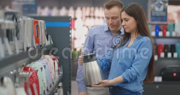 电器商店的年轻夫妇在柜台上选择了一个电热水壶视频的预览图