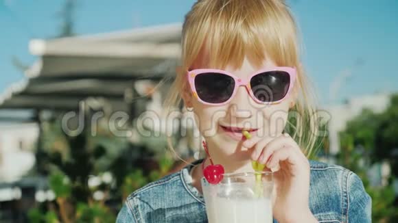 一个有趣的女孩在咖啡馆喝奶昔的肖像儿童休息概念视频的预览图