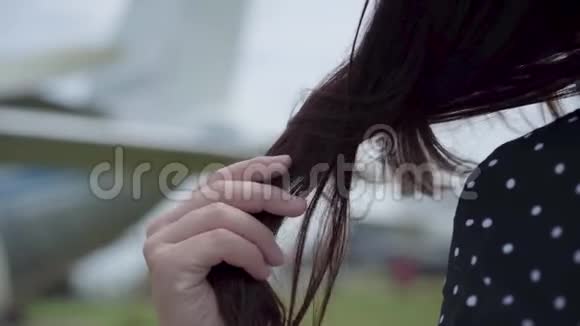 特写女性的手在模糊的平面前抚摸着她的黑发旅游飞机周末概念视频的预览图
