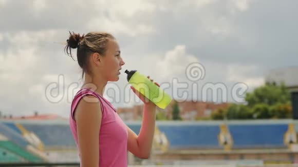 女运动员在体育场喝水视频的预览图