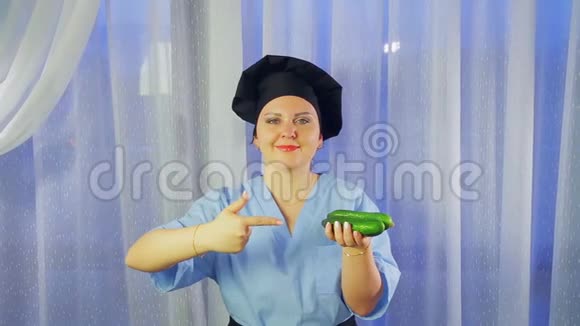 一个穿着围裙做饭的女人微笑着手里拿着黄瓜指着他视频的预览图