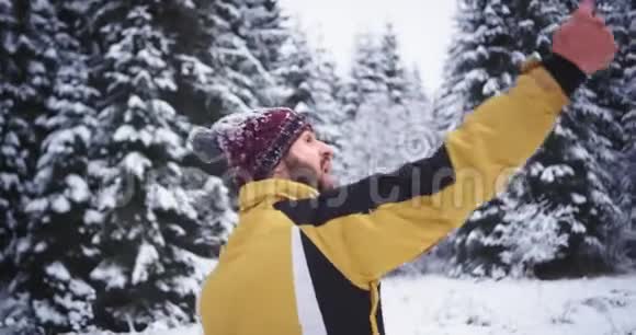 有魅力长相漂亮的游客在冬天的雪林中用手机自拍非常视频的预览图