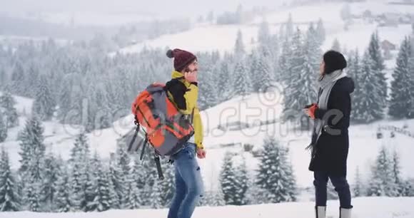 两个朋友一男一女带着雪来到了田野的顶端他们有一个休息时间视频的预览图