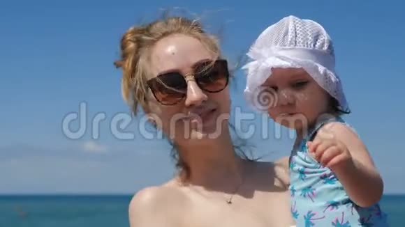 夏天在海滩上的妈妈和小可爱的视频的预览图