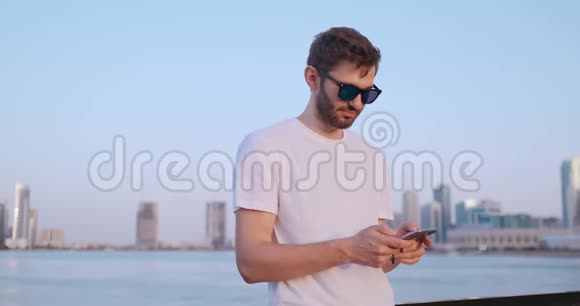 这个人拨了电话号码在迪拜全景的背景上交谈手特写视频的预览图