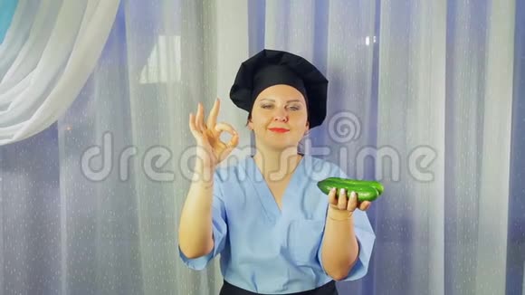 女人穿着围裙做饭微笑着手里拿着新鲜的黄瓜显示她的手还好视频的预览图