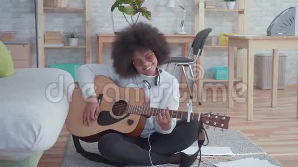 性格开朗的非裔美国女人留着非洲发型带着吉他慢节奏视频的预览图