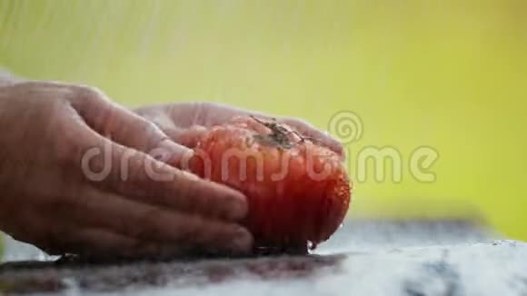 女人的手在水流下洗一个西红柿视频的预览图