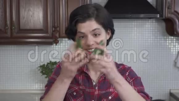 在厨房里和鳄梨鬼混的可爱女孩笑的开朗的女孩把鳄梨放在他的眼睛和视频的预览图