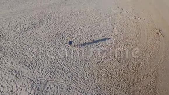 清晨一个穿着蓝色裙子的金发女郎沿着波罗的海海滩的黄沙奔跑长长的影子视频的预览图