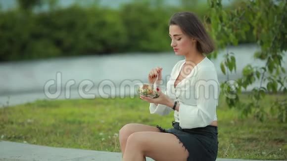 坐在公园里吃沙拉的美女视频的预览图