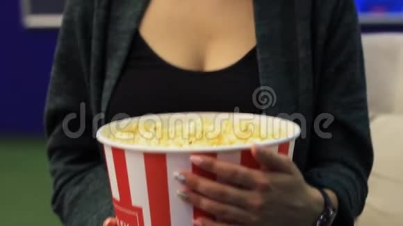 无法辨认的女人在电影院吃爆米花视频的预览图