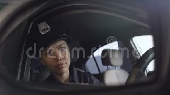 亚洲警察调整她的制服帽看后视镜视频的预览图