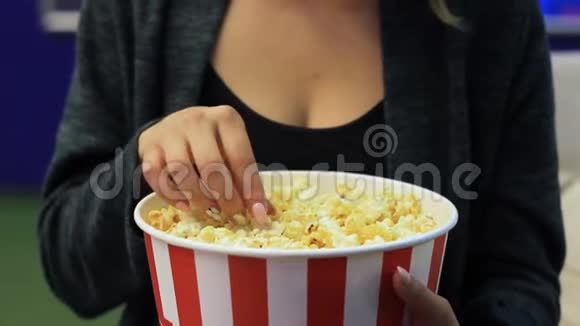 无法辨认的女人在电影院吃爆米花视频的预览图