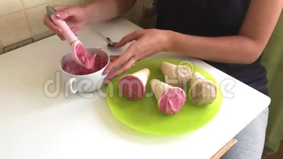 一个女人正在用勺子摘草莓冰淇淋盘子旁边放着草莓和香蕉冰淇淋关于视频的预览图