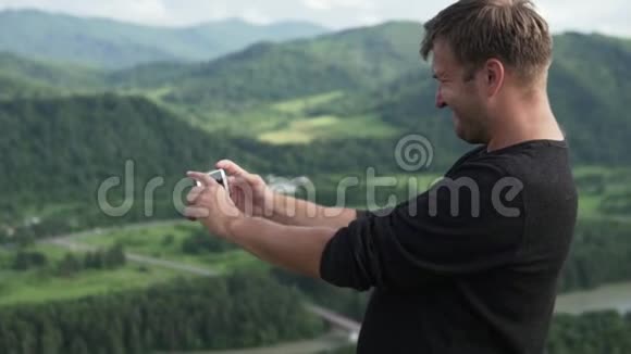 一个男人在电话里拍了一张夏天阿尔泰的照片视频的预览图